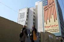 Hai phụ nữ đi qua một biểu ngữ nội dung chống Mỹ ở Tehran, Iran. Ảnh: Getty.
