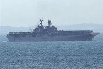 Tàu tấn công đổ bộ USS Tripoli (LHA-7) tiến vào eo biển Singapore, nhìn từ Singapore, hôm thứ Ba, ngày 17/ 3. Ảnh: Reuters.