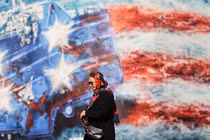 Một phụ nữ Iran đi ngang qua một bảng quảng cáo chống Mỹ ở Tehran, Iran ngày 26/2. Ảnh: Reuters.