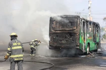 Các nhân viên cứu hỏa đang nỗ lực dập tắt ngọn lửa từ một chiếc xe bị các thành viên tội phạm có tổ chức sử dụng làm rào chắn sau một loạt vụ bắt giữ của lực lượng liên bang tại Guadalajara, Mexico ngày 22/2. Ảnh: Reuters.