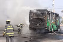 Các nhân viên cứu hỏa đang nỗ lực dập tắt ngọn lửa từ một chiếc xe bị các thành viên tội phạm có tổ chức sử dụng làm rào chắn sau một loạt vụ bắt giữ của lực lượng liên bang tại Guadalajara, Mexico ngày 22/2. Ảnh: Reuters.