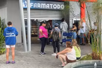 Người dân xếp hàng tại một cửa hiệu thuốc còn đang mở cửa ở Caracas, Veneuela. Ảnh: RT.