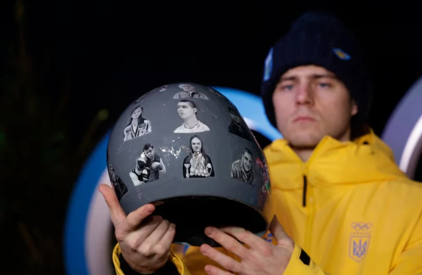 Vận động viên Vladyslav Heraskevych của Ukraine giơ cao chiếc mũ bảo hiểm đặc biệt tại một cuộc họp báo. Ảnh: Reuters.