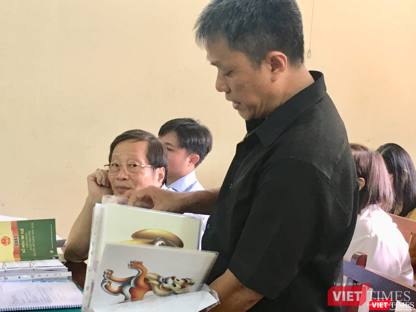 Họa sĩ Lê Linh trình bày trước HĐXX, ông Nguyễn Vân Nam (đại diện Công ty Phan Thị) bên trái ảnh Họa sĩ Lê Linh trình bày trước HĐXX, ông Nguyễn Vân Nam (đại diện Công ty Phan Thị) bên trái ảnh