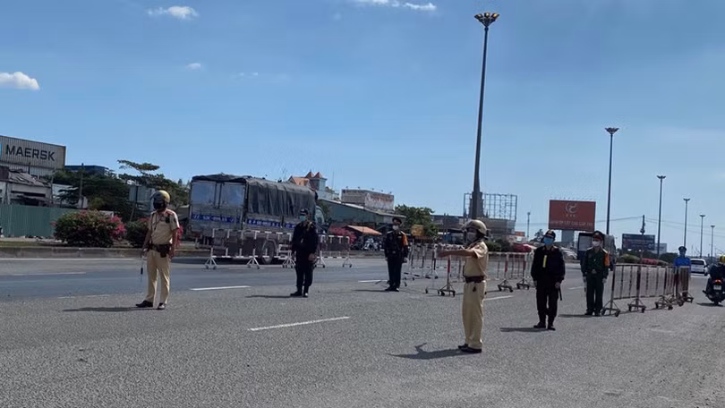 Các lực lượng triển khai hướng dẫn người điều khiển phương tiện giao thông vào đo thân nhiệt. Ảnh: Phú An