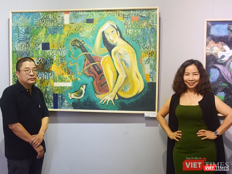 Họa sĩ Tô Chiêm (bên trái ảnh) chụp cùng với người hâm mộ bức "Nỗi niềm thương nhớ"