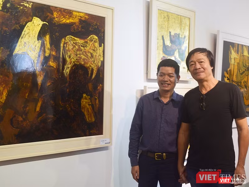 Họa sĩ Ngô Thành Nhân (áo đen bên phải) chụp ảnh lưu niệm cùng bạn bè, người thân bên cạnh tác phẩm của mình