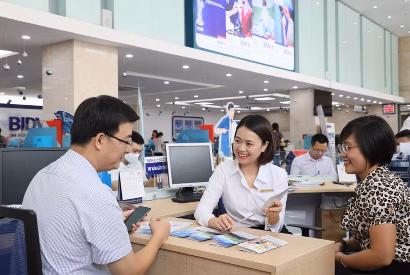 Nhân viên BIDV trao đổi vơi khách hàng. Ảnh: BIDV