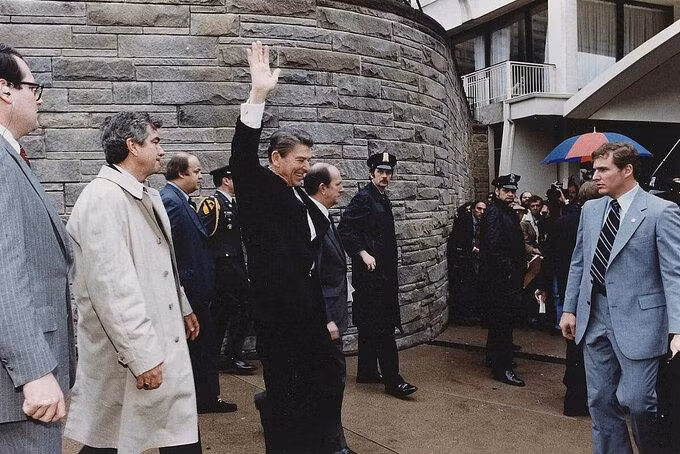 Ronald Reagan vẫy tay chào người dân và báo chí khi rời khỏi khách sạn Hilton tại Washington và bị ám sát hút chết ngày 3031981. Ảnh Corbis.