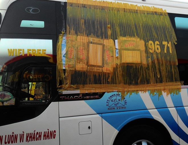 Nhân viên hãng Sơn Tùng dán băng keo ở vị trí kính vỡ khi xe khách bị ném đá. Nhân viên hãng Sơn Tùng dán băng keo ở vị trí kính vỡ khi xe khách bị ném đá.