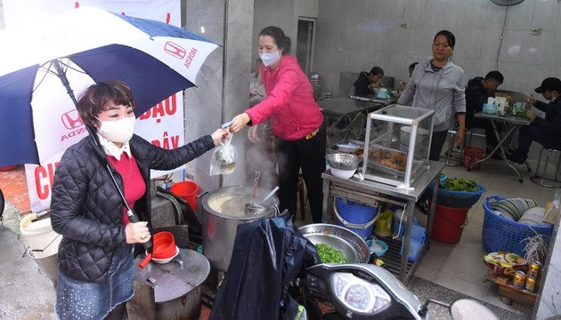 Người kinh doanh thức ăn đường phố phải đeo khẩu trang khi tiếp xúc với thực phẩm, giữ khoảng cách với khách. Ảnh: Bộ Y tế