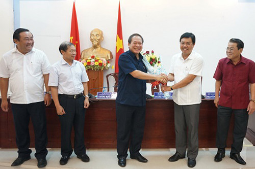 Chủ tịch UBND tỉnh Cà Mau Nguyễn Tiến Hải đại diện Đảng bộ tỉnh Cà Mau trao đổi thông tin bên lề buổi làm việc và tặng hoa Bộ trưởng Bộ TT&TT Trương Minh Tuấn trước sự chứng kiến của Bí thư Tỉnh ủy Cà Mau Dương Thanh Bình (bìa phải) và Chủ tịch HĐND, Trưởng ban Tuyên giáo Tỉnh ủy Cà Mau Trần Văn Hiện (bìa trái).