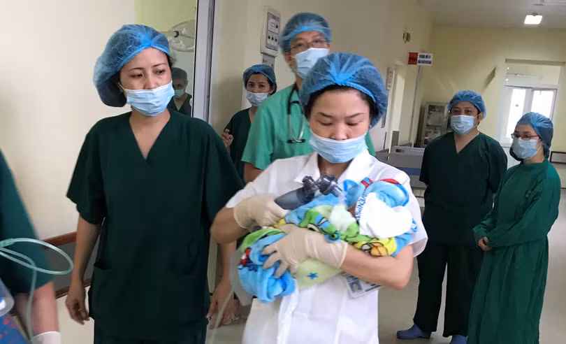 Nhóm bác sĩ đưa em bé mới sinh tới Bệnh viện Phụ sản Trung ương để chăm sóc