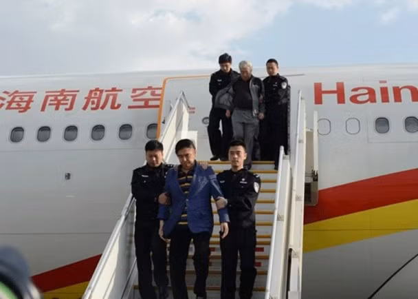 Một tội phạm lẩn trốn bị bắt áp giải về nước.