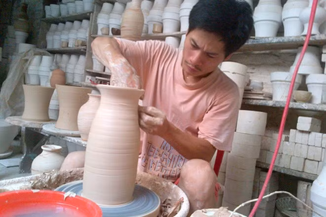Nghệ nhân Hà Nội Phạm Anh Đạo bên bàn xoay với một sản phẩm gốm được làm theo phương pháp cổ truyền: vuốt- nặn- vẽ- Ảnh nhân vật cung cấp.