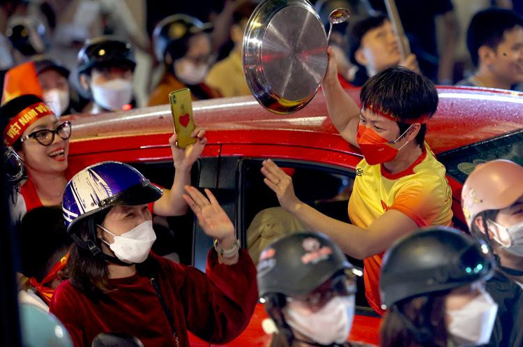Nhiều người dân diễu hành mang cả xoong chảo, mâm sắt, nồi khuấy động... cùng dòng người đứng bên đường tạo nên không khí hoạt náo, vui mừng khắp nơi.
