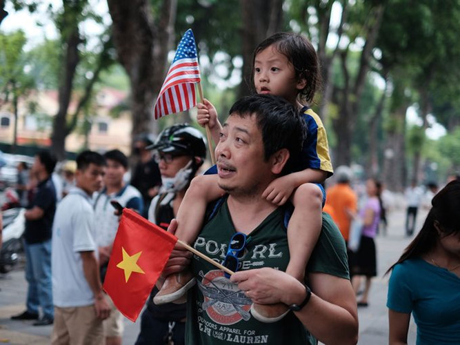 Một người cha và con gái đứng chờ đoàn xe chở Tổng thống Mỹ đi qua. (Ảnh: Getty Images)