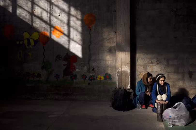 Hai cô gái trẻ Afghanistan chờ được đăng ký tại Trung tâm đăng ký Tabakika. Hàng ngàn người tị nạn và người di cư tiếp tục tấp vào bờ của Hy Lạp bất chấp thời tiết lạnh giá.