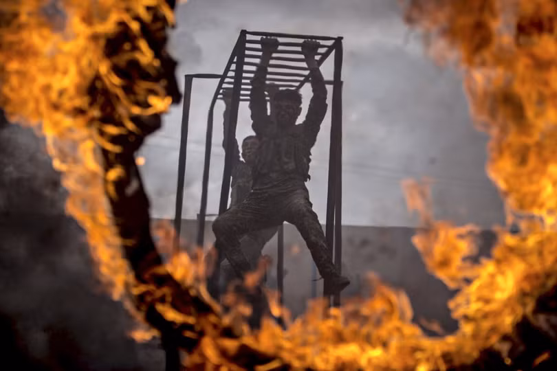 Ở Syria, các thành viên của lực lượng YPG của người Kurd luyện tập trên thanh khỉ và trở ngại lửa.