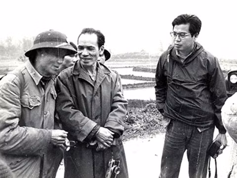 Takano (đeo kính) trên đường tác nghiệp.