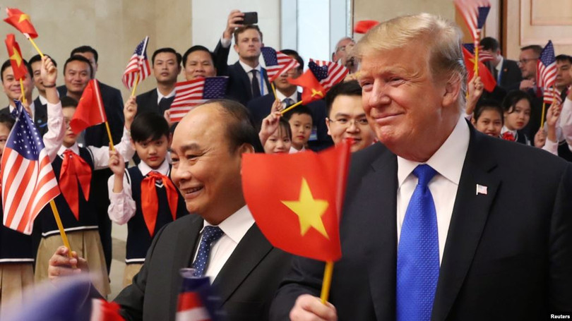 Tổng thống Mỹ Donald Trump và Thủ tướng Việt Nam Nguyễn Xuân Phúc vẫy cờ khi được các em học sinh chào đón tại trụ sở Văn phòng Chính phủ ở Hà Nội, ngày 27 tháng 2, 2019. (Ảnh: Tư liệu)