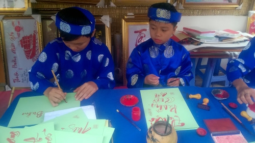 Hai Ông Đồ "nhí" đang say sưa cho chữ.