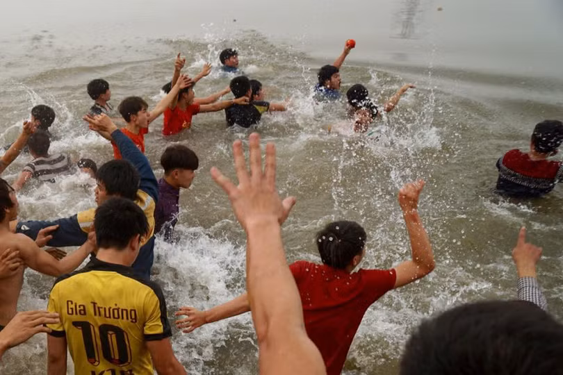 Một người sau khi giành được quả phết phải nhảy xuống sông bơi qua bờ bên kia để có thể thoát được đám đông đang vây đuổi. Ảnh:Hiếu Trần.