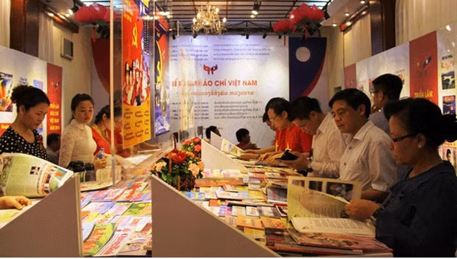 Công chúng Việt, Lào xem các ấn phẩm trưng bày tại một triển lãm báo chí được tổ chức gần đây. Ảnh minh hoạ: Báo Nhân dân.