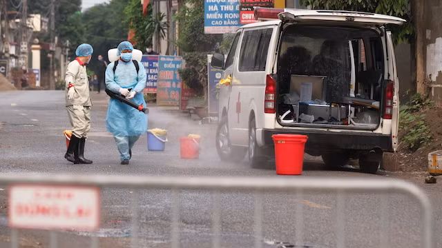 Lực lượng chức năng phun khử khuẩn phía trước ngôi nhà bệnh nhân 243. Ảnh: CDC Hà Nội.