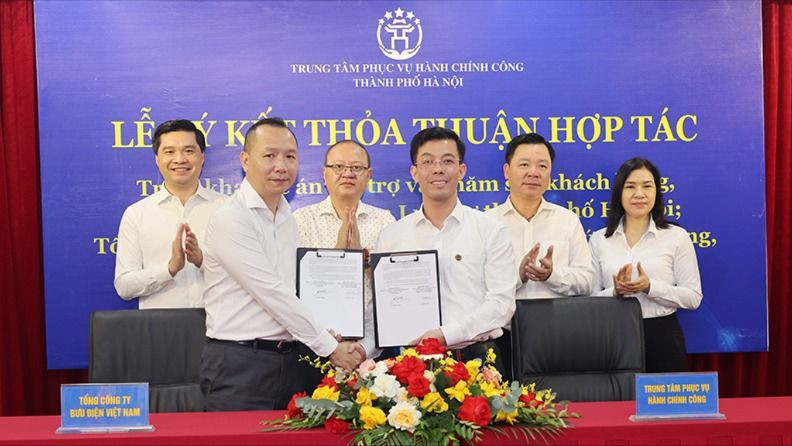 Đại diện Tổng công ty Bưu điện Việt Nam và Trung tâm phục vụ Hành chính công TP. Hà Nội ký kết thỏa thuận hợp tác triển khai cung ứng nhân lực hỗ trợ người dân thực hiện thủ tục hành chính.