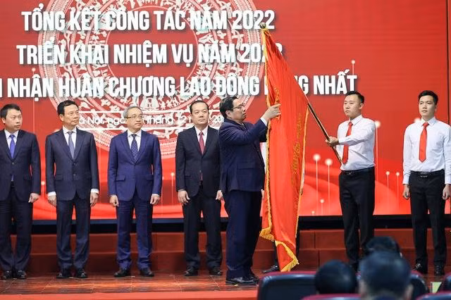 Thủ tướng gắn Huân chương Lao động hạng Nhất lên lá cờ truyền thống của Bộ Thông tin và Truyền thông, ghi nhận những nỗ lực, thành tích xuyên suốt trong thời gian qua và trong năm 2022 của Bộ.