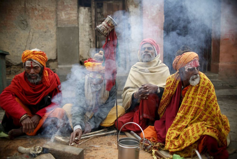 Các thánh nhân Hindu “Sadhu” ngồi bên đống lửa trong đền thờ Pashupatinath ở Kathmandu, Nepal 