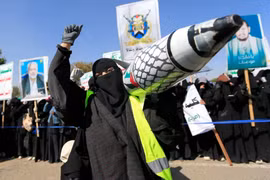 Một phụ nữ Yemen giơ cao một tên lửa giả được trang trí bằng màu cờ Palestine trong một cuộc biểu tình ở Sanaa vào ngày 15/1. Ảnh: AFP.