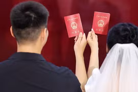 Một cặp vợ chồng mới cưới tạo dáng chụp ảnh tại văn phòng đăng ký kết hôn Lâm Nghi, Trung Quốc vào ngày 10/8/2024 (Ảnh: Getty)