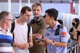 Cảnh sát đang trả lời các câu hỏi về giấy phép nhập cảnh miễn thị thực cho du khách nước ngoài tại một sân bay ở Bắc Kinh. Chính sách nhập cảnh miễn thị thực của Trung Quốc đã thúc đẩy lượng du khách nước ngoài tăng vọt trong 2 năm qua. Ảnh: Xinhua.