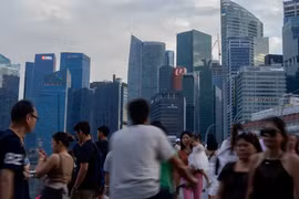 Du khách đến Vịnh Marina đi bộ trên cây cầu nhìn ra Khu thương mại trung tâm ở Singapore (Ảnh: Getty)