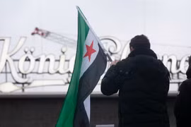 Người Syria tị nạn phản ứng trước những diễn biến mới ở Syria tại Ga trung tâm Duisburg ở Duisburg, Đức. Ảnh: Getty.
