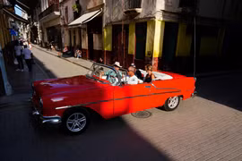Khách du lịch đi trên một chiếc xe cổ ở Havana, Cuba, tháng 3/2024. Đường phố Havana vẫn còn đầy những chiếc xe có từ trước cuộc cách mạng năm 1959. Ảnh: Reuters.