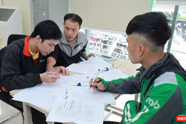 Nhân viên Bưu điện hướng dẫn khách hàng làm thủ tục đăng ký cấp phiếu lý lịch tư pháp tại bưu cục Thăng Long.