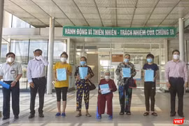 Bệnh nhân 592 (ngồi) cùng các bệnh nhân mắc COVID-19 được công bố khỏi bệnh và cho xuất viện về nhà
