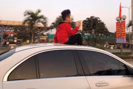 Em bé ngồi trên cửa sổ trời ô tô khiến nhiều người thảng thốt. (Ảnh: Thế giới trẻ) 