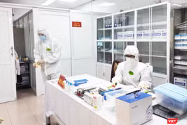 Nhân viên y tế làm việc trong phòng lấy mẫu (Ảnh - Minh Thuý) 