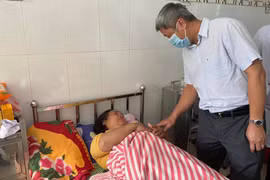 Thứ trưởng Bộ Y tế Nguyễn Trường Sơn thăm hỏi nạn nhân trong vụ sạt lở đất ở Trà Leng (Ảnh: Vũ Mạnh Cường) 