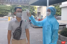 Người dân được kiểm tra nhiệt độ trước khi vào bệnh viện (Ảnh - Minh Thuý) 