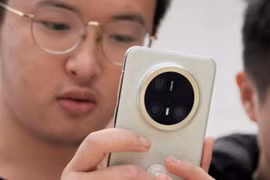 Một du khách đang xem dòng điện thoại thông minh Mate 70 mới nhất của Huawei tại một cửa hàng ở Bắc Kinh. Ảnh: Reuters.
