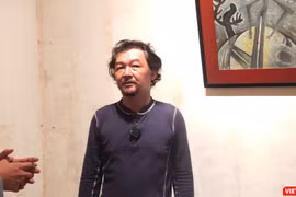 Họa sĩ Huỳnh Lê Nhật Tấn trả lời phỏng vấn tại triển lãm "Vết căn nguyên". Ảnh: Hòa Bình