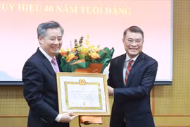 Trưởng Ban Tổ chức Trung ương Lê Minh Hưng trao Huy hiệu 40 năm tuổi Đảng cho ông Nguyễn Quang Dương (trái).