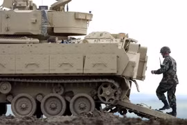 Một người lính đang đi bộ phía sau chiếc xe Bradley Fighting Vehicle trong cuộc diễn tập tại Fort Riley, Kansas (Ảnh Getty Images)