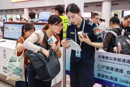 Nhân viên an ninh sân bay kiểm tra cục sạc dự phòng của hành khách. Ảnh: Sohu.