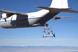 Cánh tay máy đang "gắp" chiếc UAV X-61 Gremlins vào trong khoang sau khi kết thúc chuyến bay thử (Ảnh: DARPA).